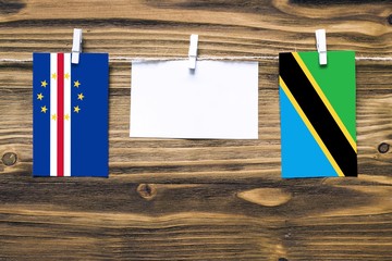 Hanging flags of Cape Verde and Tanzania attached to rope with clothes pins with copy space on...