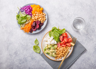 Two plates Buddha Bowls  and glass of water. Concept for  healthy vegetarian detox balanced  meal. Top view. Copy space.