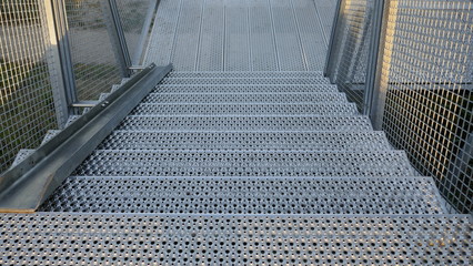 Fototapeta premium Grate steel staircase. External staircase with rail for bicycles on a cliff in Hohwacht, Schleswig-Holstein, Germany