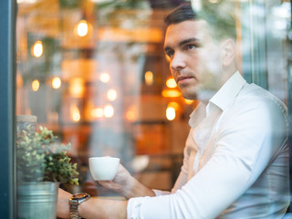 Confident young man enjoying coffee