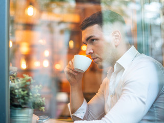 Confident young man enjoying coffee