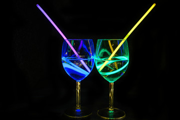 Exotic alcoholic transparent beverages in wine glass with dark background for party celebration, new year, bar and christmas with straw