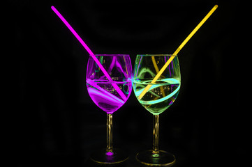 Fresh alcoholic transparent beverages in wine glass with dark background for party celebration, new year, bar and christmas with straw