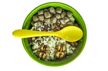 healthy breakfast concept. good food. cottage cheese with bran, flaxseeds and walnuts. green plate. yellow spoon. Suitable for illustrating a recipe, an article on malnutrition.