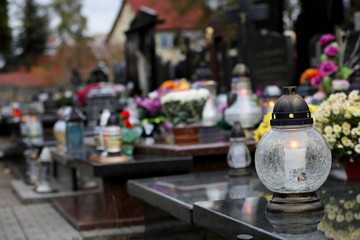 bouquet of flowers in a vase at the cemetery, candles on the grave