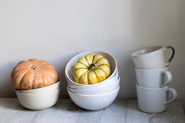 Pumpkins in white ceramic bowls as decoration for the kitchen interior for Halloween