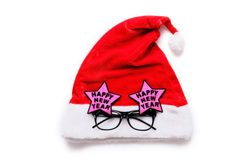 Red Santa Claus hat with festive glasses on white background, top view