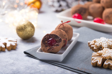 Christmas Sweet candies on the dessert table . Balls of biscuit with cherry - loli pop or cake pop. New year decoration and apple cider drink. happy holidey concept