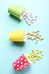 Colorful paper stars with cups on blue background