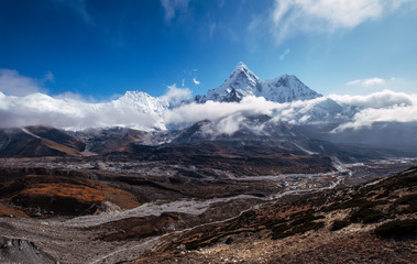 Wide angle view to Ama Dablam 6814m peak covered with clouds and Chukhung village 4730m liying on Imja Khola river bank Sagarmatha National Park. Everest Base Camp (EBC) trekking route.
