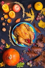 Roast chicken or turkey with fruits, pumpkins and berries. Autumn decorations on the table. Thanksgiving food background, flat lay