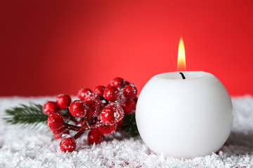 Obraz na płótnie Canvas Christmas candle with berries on red background