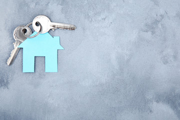 Silver keys with house symbol on grey background