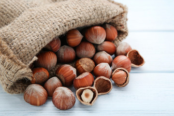 Hazelnuts with sack on wooden table