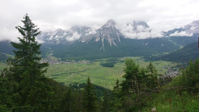 Picturesque view of mountain chains and green alpine landscape on a cloudy day.