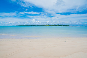 Kayangel main island view from small island shore, calm blue ocean, tropical beach and green island, Palau, Pacific