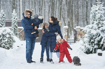 Happy family have a fun outside near the house in winter