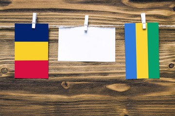 Hanging flags of Chad and Gabon attached to rope with clothes pins with copy space on white note...