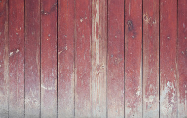 old and worn red wooden panels in a vertical fence - background texture