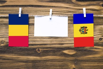 Hanging flags of Chad and Moldova attached to rope with clothes pins with copy space on white note...