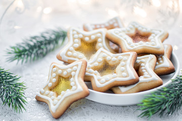 Homemade Christmas star shape sugar caramel cookies on white background  with fir-tree branches