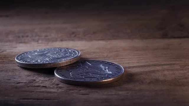 two silver dollar coins in slow motion