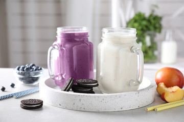 Tasty milk shakes in mason jars on tray