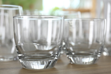 Empty glasses on wooden table against blurred background