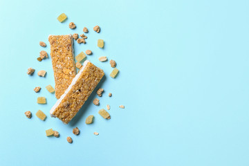 Healthy granola bars on blue background, flat lay. Space for text