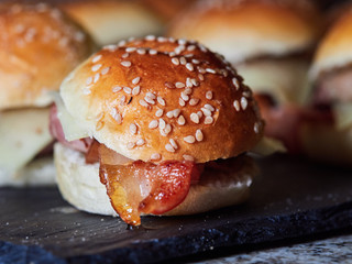 several Minicheeseburguers on black slate stone