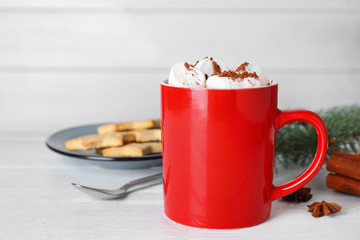 Composition of tasty cocoa with marshmallows in cup on white wooden table