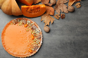 Flat lay composition with delicious fresh homemade pumpkin pie on grey table. Space for text
