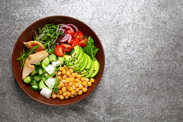Delicious avocado salad with chickpea on grey table, top view. Space for text