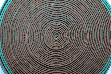 Brown belt tape with a green fringing. Belt roll for the manufacture of bags and backpacks. Babin cloth brown slings close-up