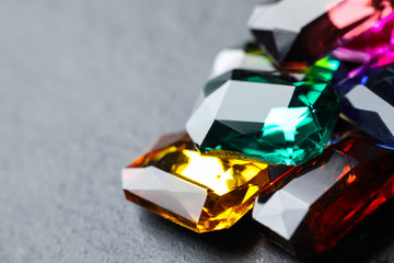 Beautiful gemstones for jewelry on grey background, closeup. Space for text