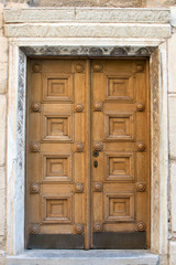 Vintage beautiful wooden door with carved elements. Large massive front door to the building. Closed entrance double doors.