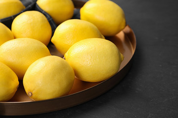 Fresh ripe lemons on dark table, closeup