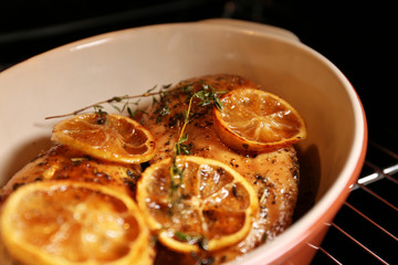 Baking dish with delicious lemon chicken in oven, closeup view