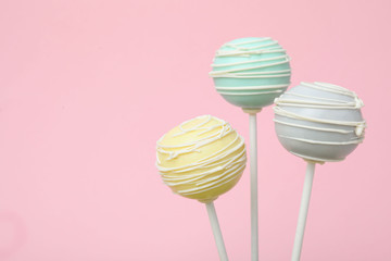 Sweet colorful cake pops on pink background