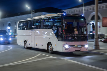 Tourist bus moves at night on a city street - 299657366