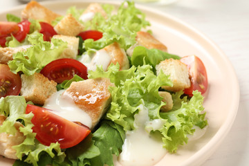 Delicious fresh Caesar salad on plate, closeup