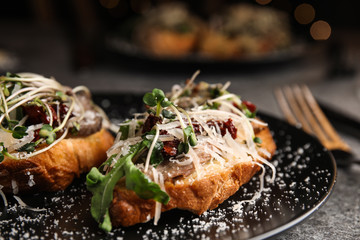 Delicious bruschettas with beef and cheese on table, closeup