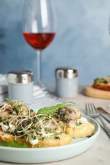 Delicious bruschettas with fish on light table