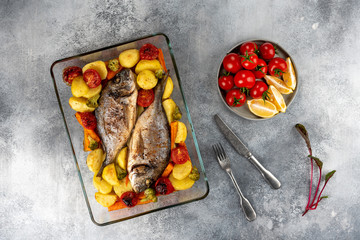 Baked dorado (dorada) fish on a plate, top view