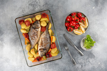 Baked dorado (dorada) fish on a plate, top view