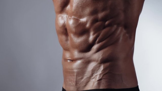 Bodybuilder posing in studio. Handsome shirtless athletic man