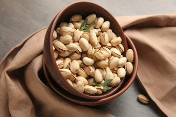 Bowls with tasty pistachio nuts on table