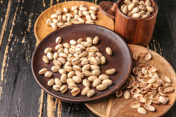 Tasty pistachio nuts on dark table