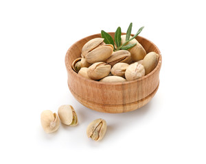 Bowl with tasty pistachio nuts on white background