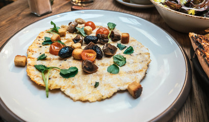 Barcelona, Spain - Nov 2017: Overhead view of ypical Catalan cuisine appetizer dish with fresh roasted tomatoes, mushrooms, dried olives, green basil a stylized baked pan